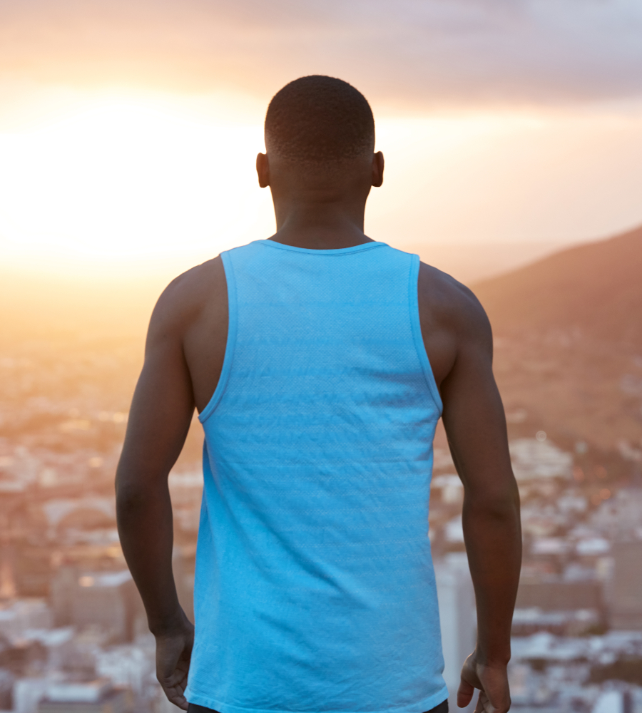 an ambitious inidivual young man staring into the horizon with his back facing the camera
